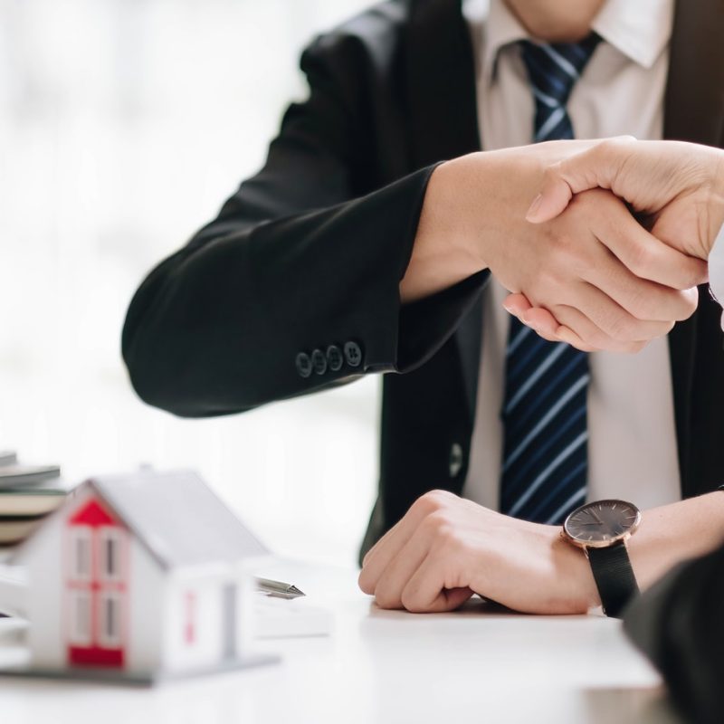 Real estate broker and customer shaking hands after signing a contract: real estate, home loan and